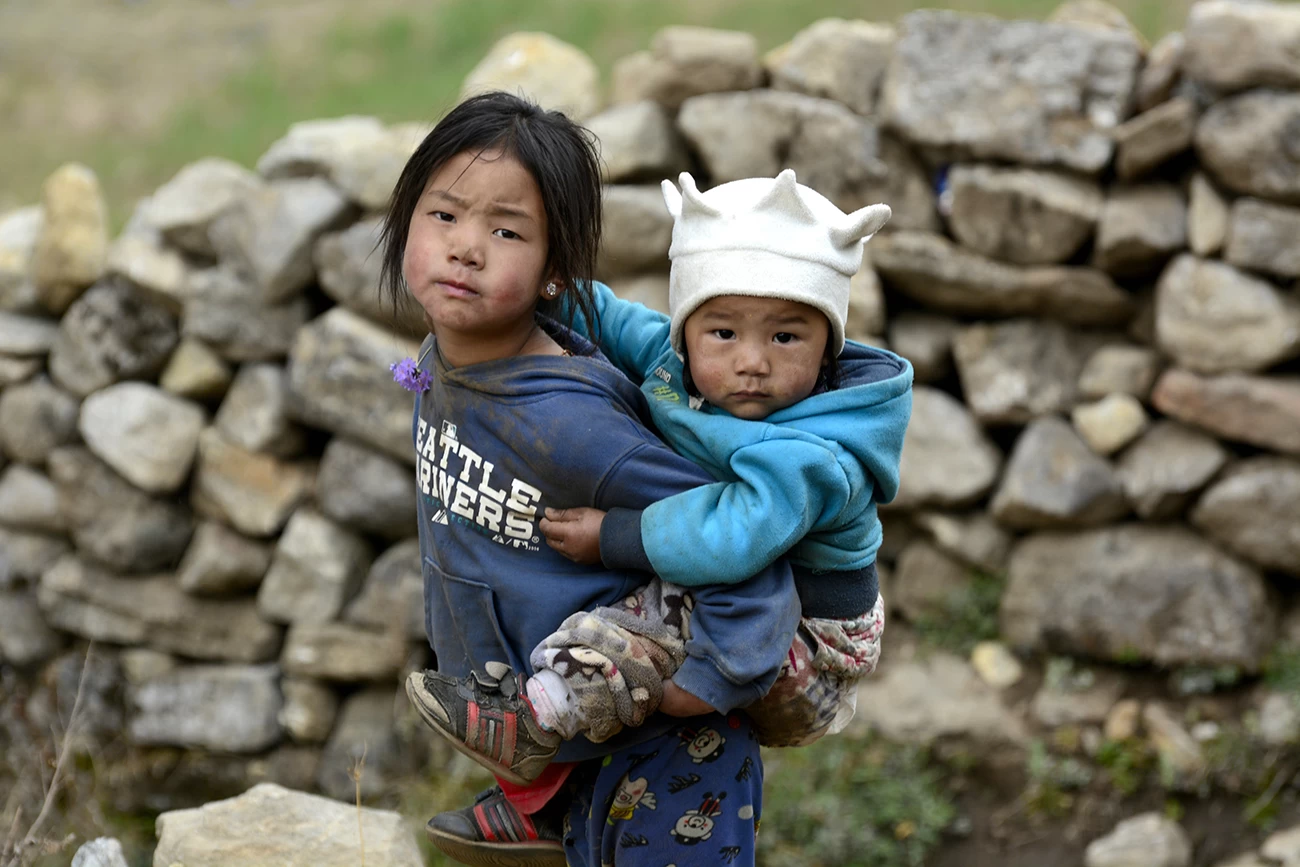 Little Girl takes care of her little sister in the mountains of Nepal.