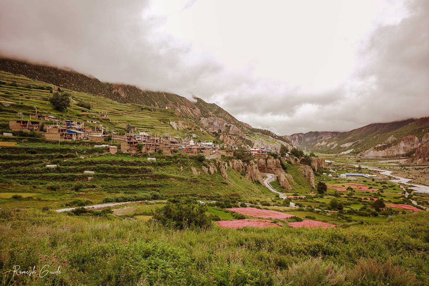 Manang Valley surrounded by misty mountains under cloudy summer skies in Nepal